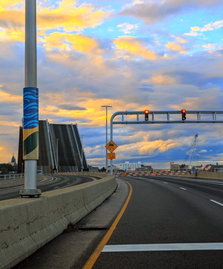 View of a red stop light and the road ahead closed as the bridge opens over the waterway below